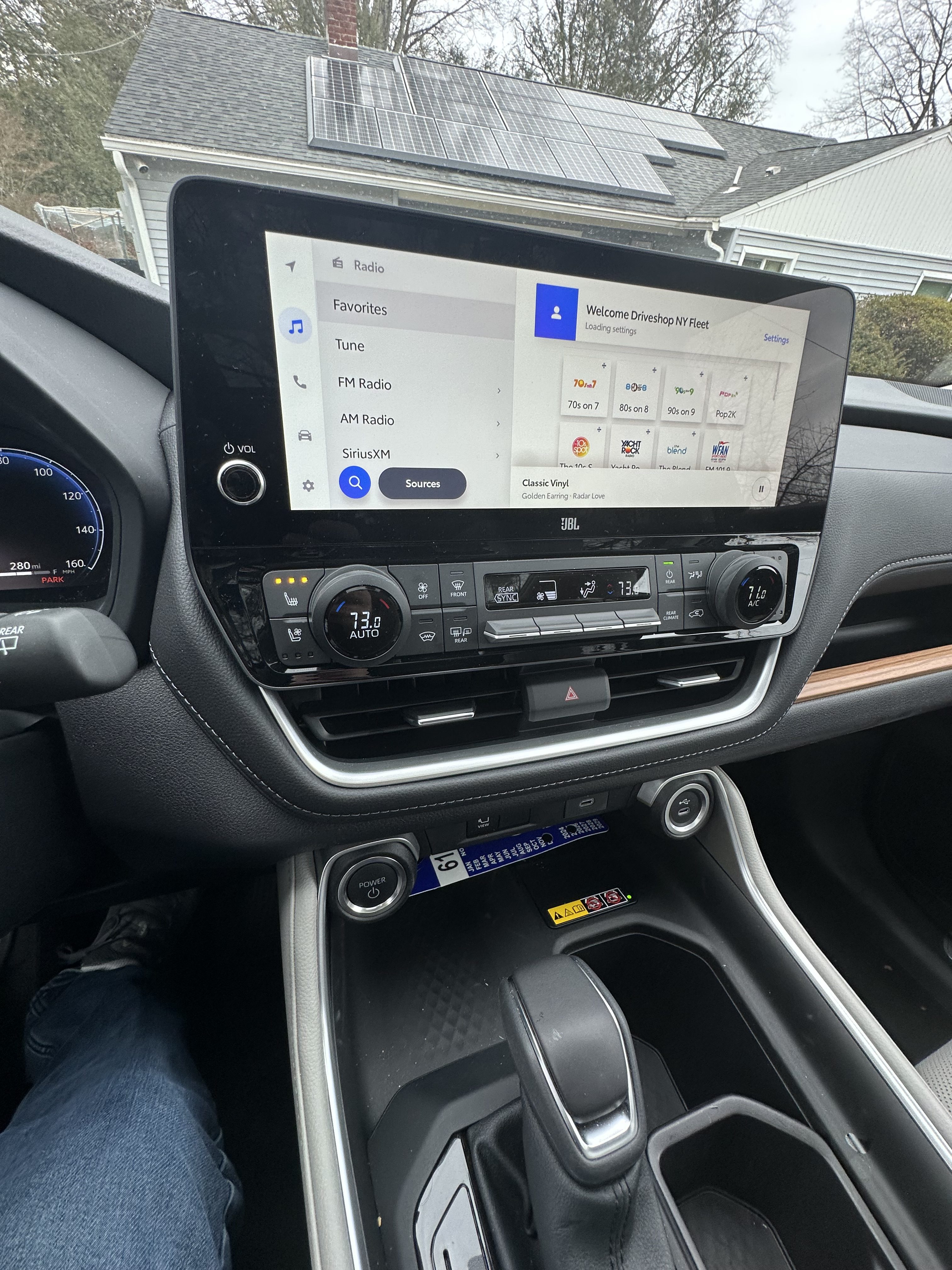 Vue intérieure d'un tableau de bord de voiture doté d'un écran tactile avec options radio et paramètres de climatisation. Toyota Grand Highlander Limitée Hybride 