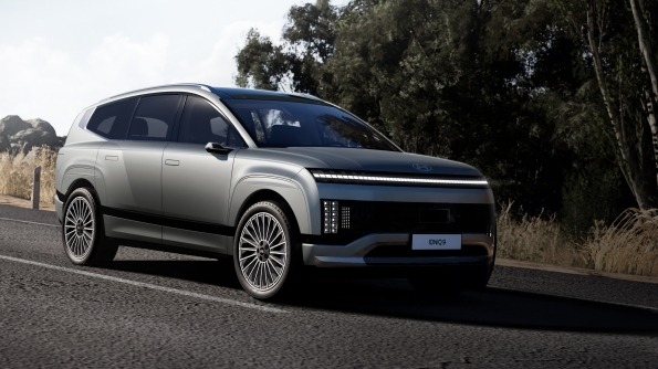 Silver SUV with modern design parked on asphalt road near trees